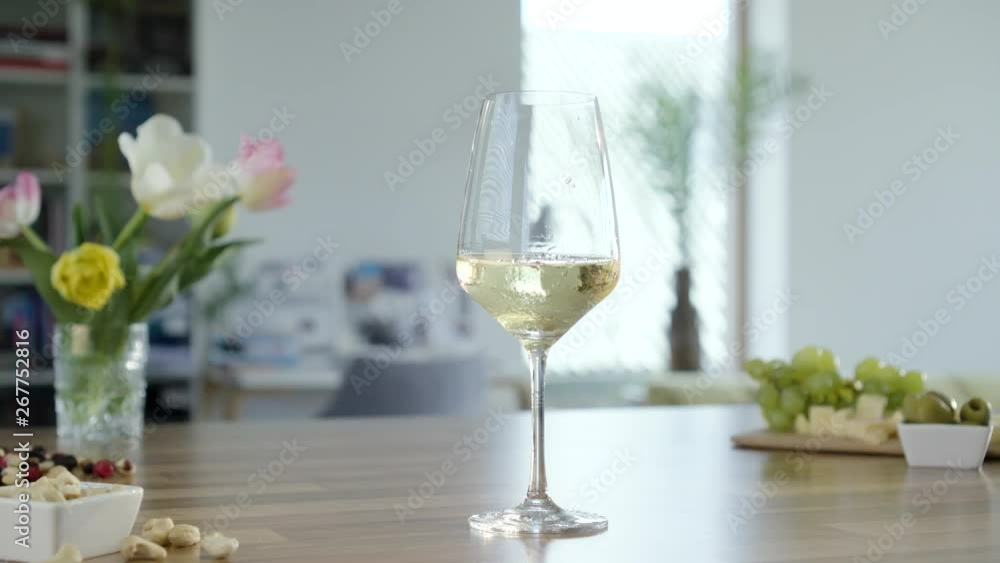 Hand takes glass of red wine and place it back on the table. Hand takes glass of red wine and place it back on the table.