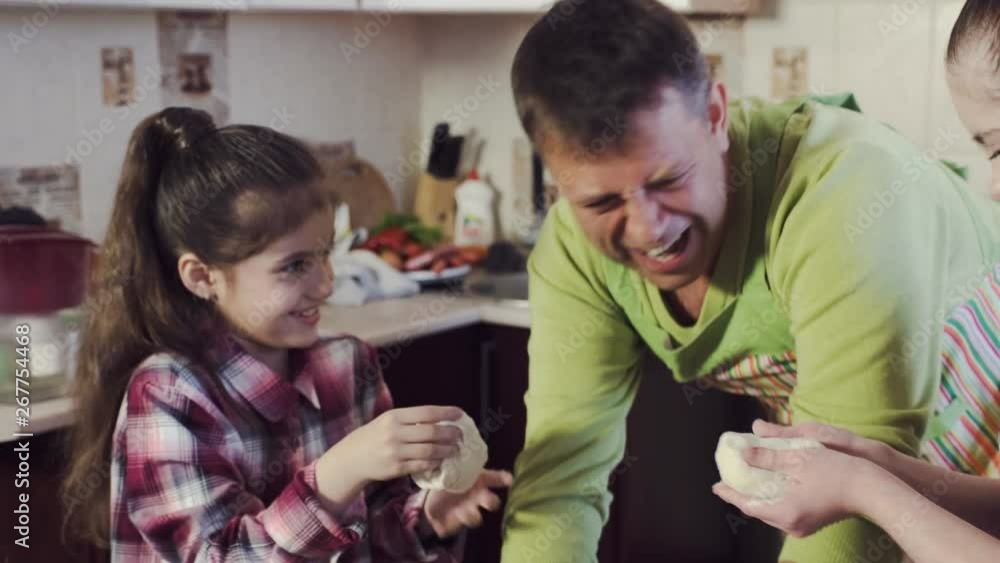 girl with down syndrome and little sister prepare smiling delicious thick dough under father guidance in kitchen girl with down syndrome and little sister prepare smiling delicious thick dough under father guidance in kitchen