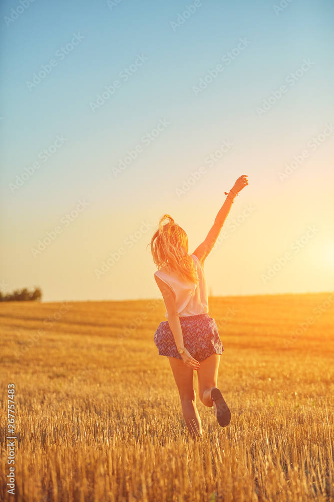Cute young woman jumping in a wheat field. Cute young woman jumping in a wheat field.