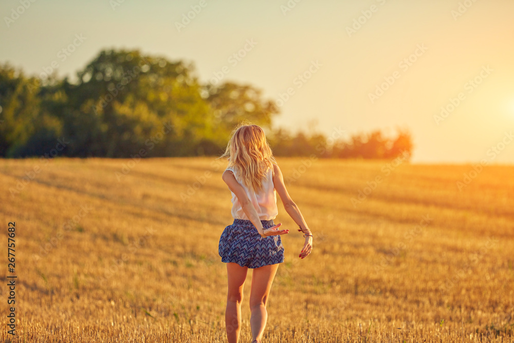 Cute young woman jumping in a wheat field. Cute young woman jumping in a wheat field.