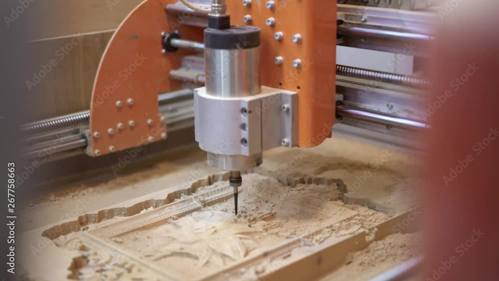 Handheld shot of an electric milling saw machine cutting wood with ornament elements. Orange electring milling machine cutting ornaments on wood Handheld shot of an electric milling saw machine cutting wood with ornament elements. Orange electring milling machine cutting ornaments on wood