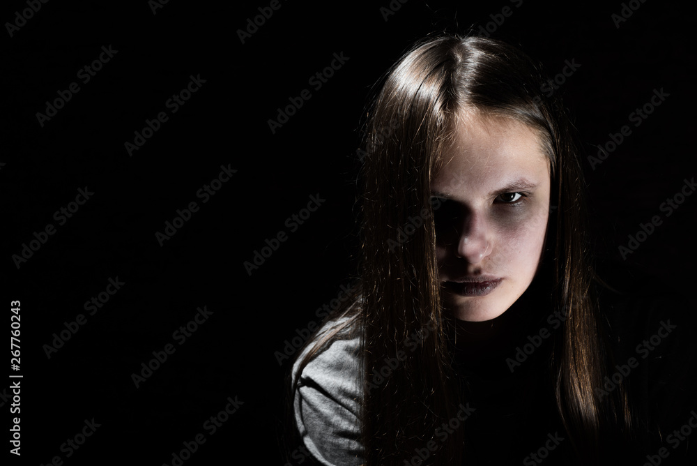 portrait of young teenager brunette girl with long hair in the Gothic style on a black background with copy space portrait of young teenager brunette girl with long hair in the Gothic style on a black background with copy space