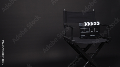 Clapperboard or movie slate with director chair use in video production ,film, cinema industry on black background.