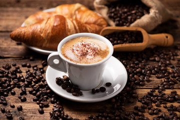 Foto auf Leinwand Küche Eine Tasse Cappuccino mit Kaffeebohne als Hintergrund.  © Fabio Balbi