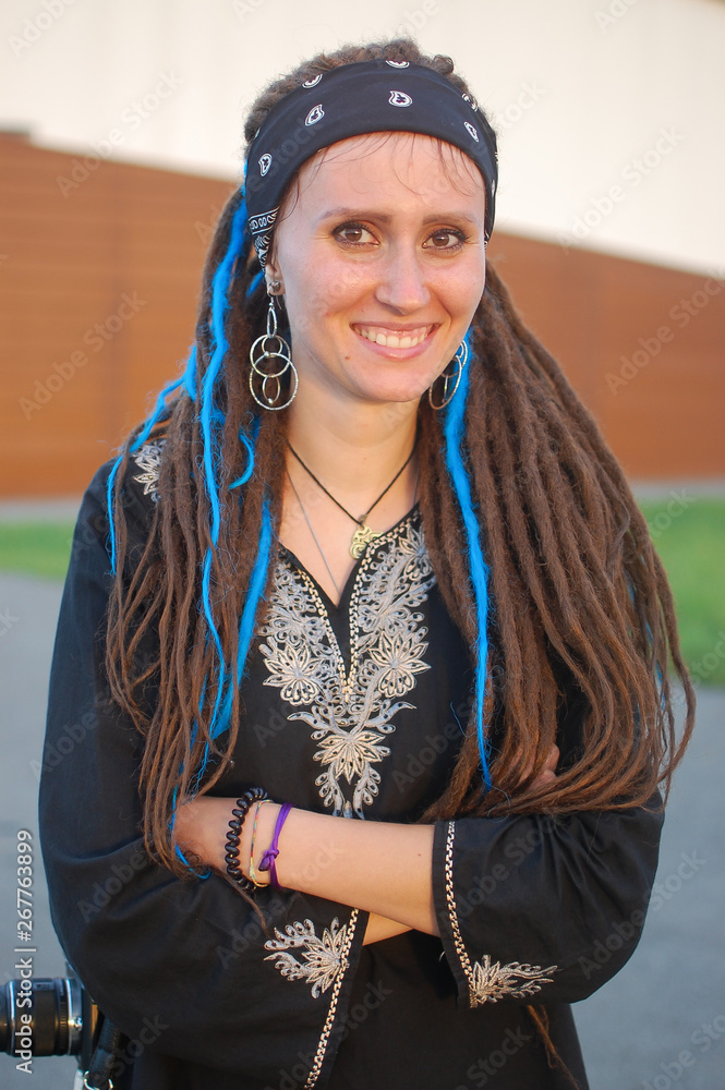 Smiling gypsy girl with long dreadlocks. Boho style young woman with dreadlocks. Natural beauty Smiling gypsy girl with long dreadlocks. Boho style young woman with dreadlocks. Natural beauty