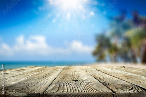 Desk of free space and summer background of beach with palms and summer sea 