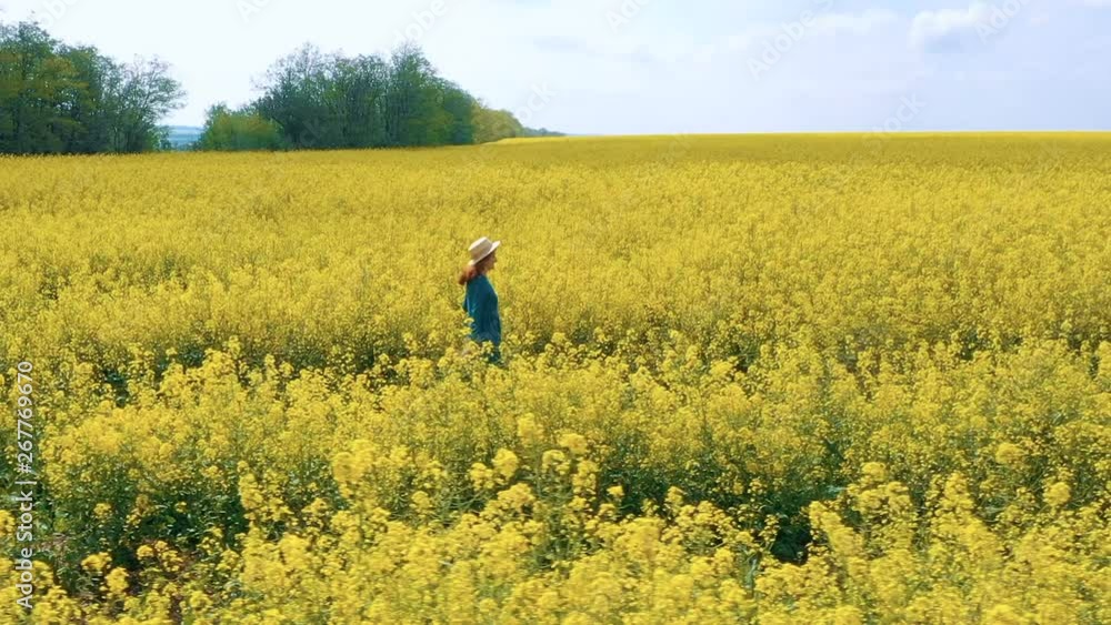 happy beautiful girl enjoying at the blooming rapeseed field at bright sunny day happy beautiful girl enjoying at the blooming rapeseed field at bright sunny day