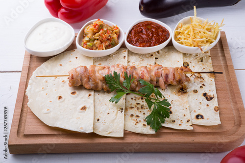 Cooked chicken kebab on a wooden board