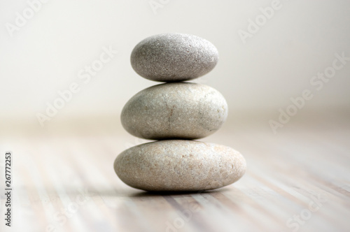 Harmony and balance, cairns, simple poise stones on wooden light white gray background, simplicity rock zen sculpture