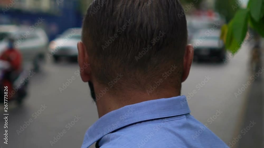 Young businessman standing by city street Young businessman standing by city street