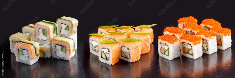 Elite sushi rolls on a black background. Assortment of rolls with different fillings. Elite sushi rolls on a black background. Assortment of rolls with different fillings.