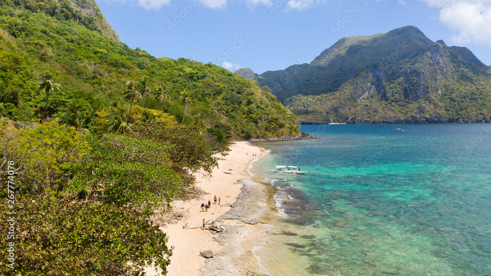 Tourists relax on the white beach of the island of Helikopter.Tropical white sand beach. Seascape with tropical islands. Tourists relax on the white beach of the island of Helikopter.Tropical white sand beach. Seascape with tropical islands.