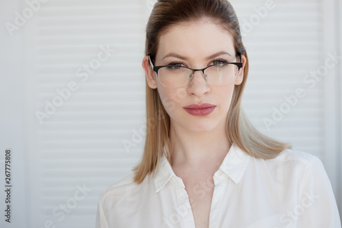 Stylish glasses in a thin frame, vision correction. Portrait of a young woman