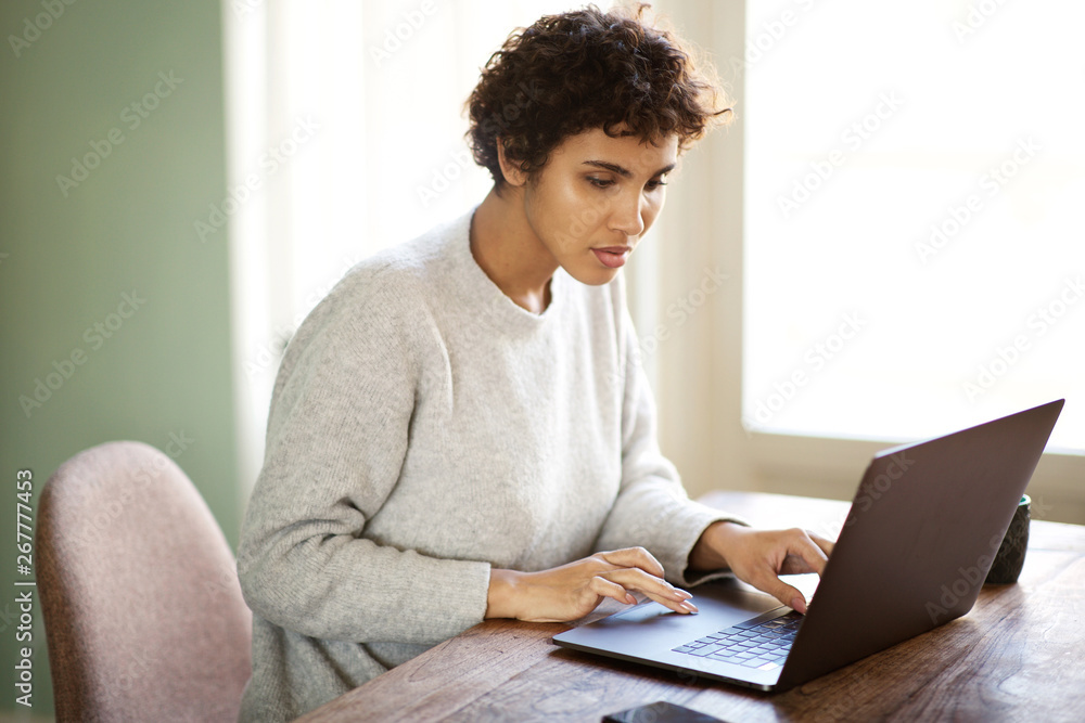 attractive young african american woman working on laptop computer at home attractive young african american woman working on laptop computer at home