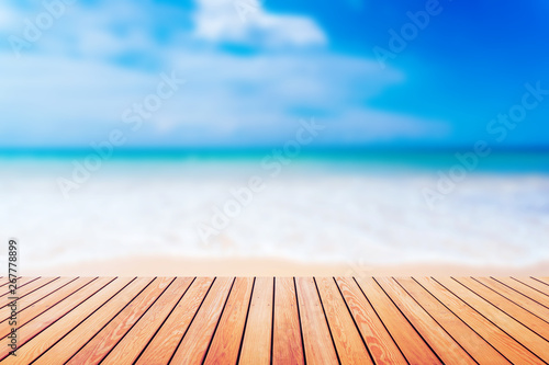Blur tropical beach with bokeh sun light wave on empty old wood table abstract background.