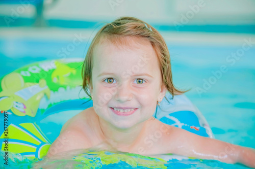 Funny portrait of happy cute little child girl at swimming pool