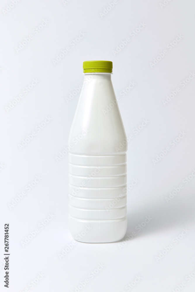 White plastic bottle for milk, mock up on a light background. White plastic bottle for milk, mock up on a light background.