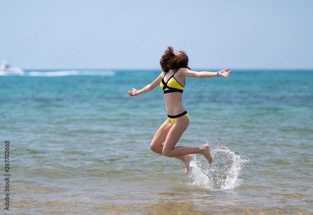 Young energetic woman jumping in the sea Young energetic woman jumping in the sea