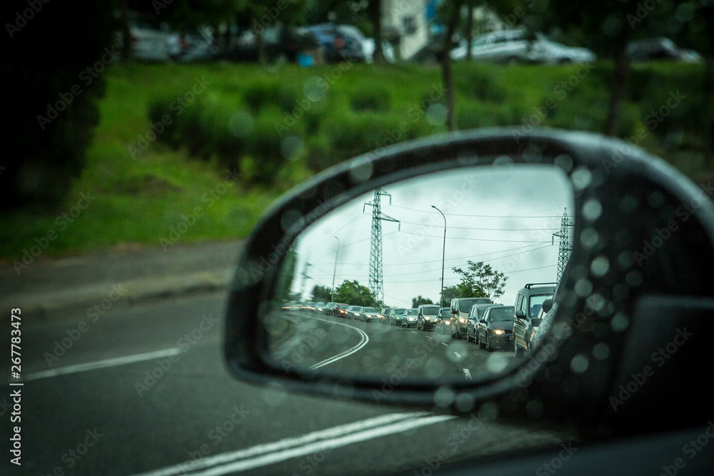 a side mirror of a car in rainy weather and traffic jams. a side mirror of a car in rainy weather and traffic jams.