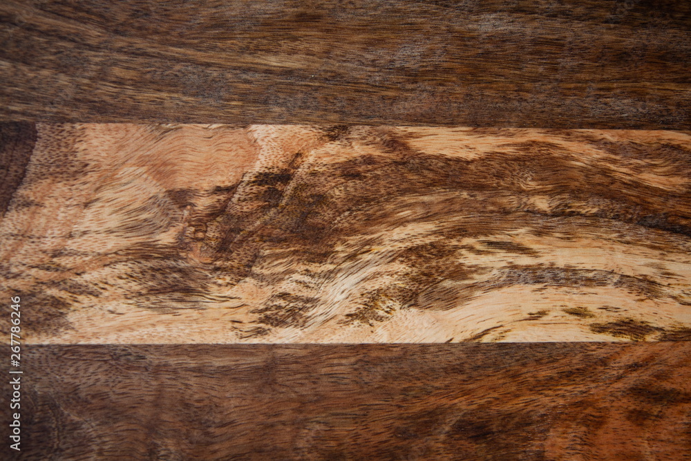 Fototapeta premium The contrasting pattern of wood on a wooden board from mango tree. The texture of the mango tree