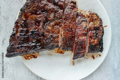 sliced grill cooked ribs on plate with barbecue glaze flat lay