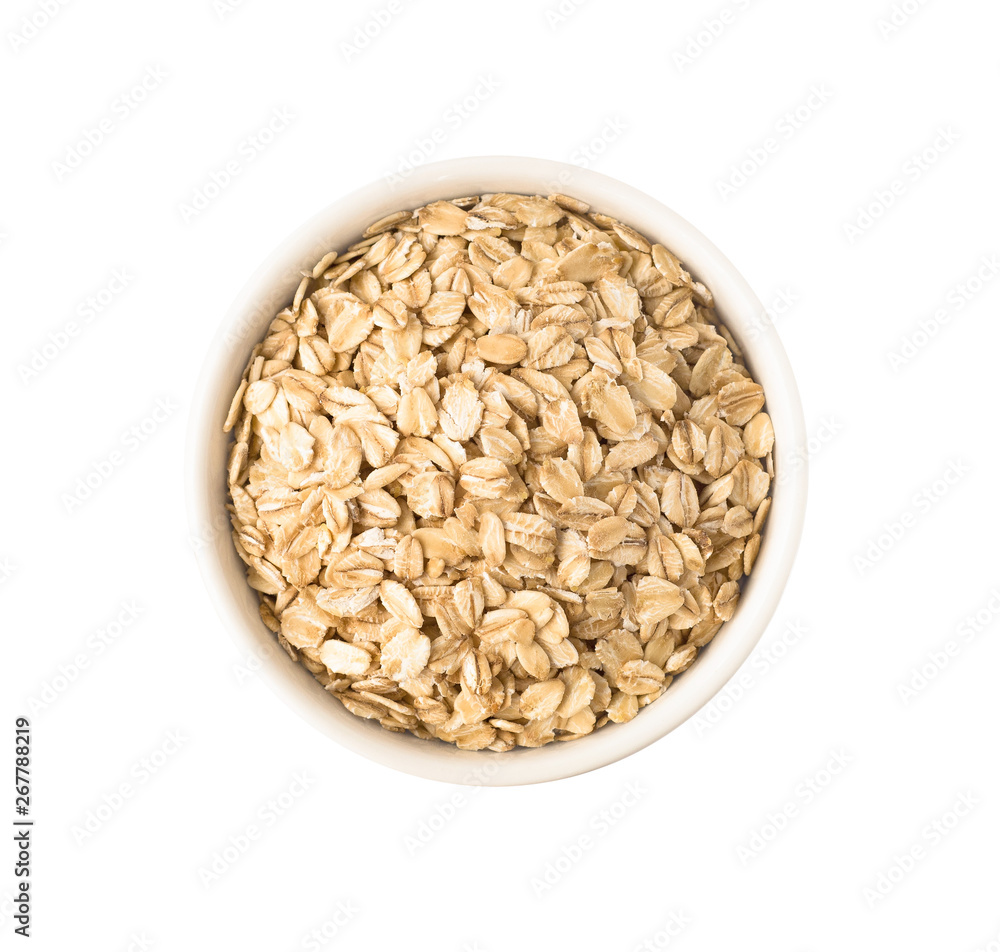 Top view uncooked oat flakes in round ceramic plate. Raw food ingredient isolated on white background Top view uncooked oat flakes in round ceramic plate. Raw food ingredient isolated on white background
