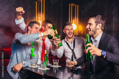 Photography Group of young men toasting at a nightclub