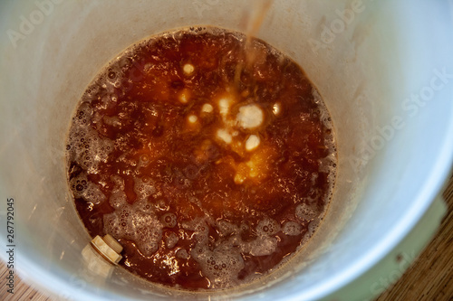Pouring homemade beer in a barrel, home brew