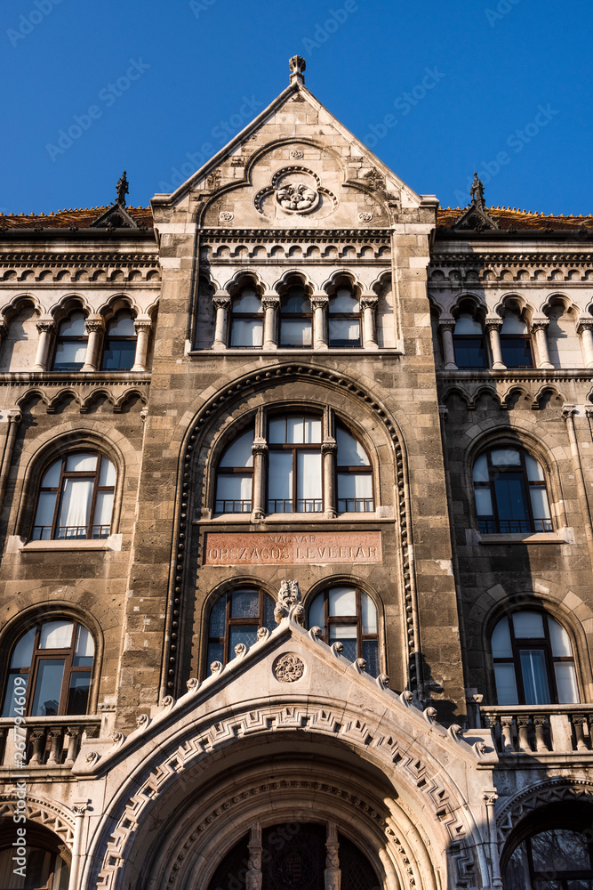 Hungary, Budapest: Front facade of famous National Archives of Hungary building in the city center of the Hungarian capital from below with blue sky in the background - concept archive history