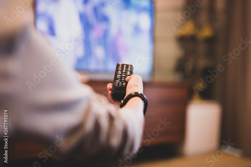 Hand using remote controller for Watching TV.