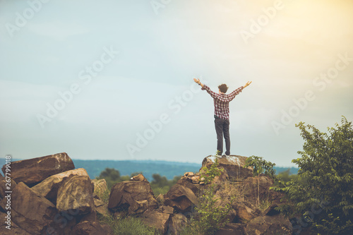 Tourist man hiker on top of the mountain.happy traveler overcome the limits of life,