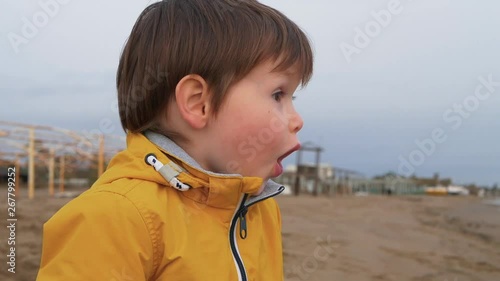 Young boy on the beach is very excited and surprised