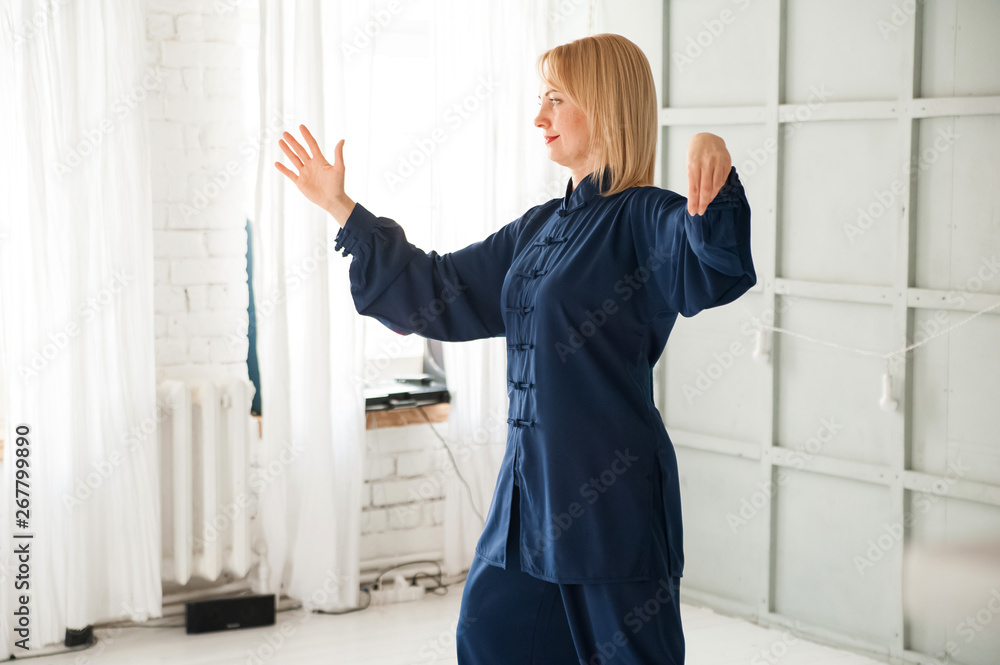Chinese martial arts tai chi. Woman practicing Taijiquan discipline in blue kimono. Chinese martial arts tai chi. Woman practicing Taijiquan discipline in blue kimono.