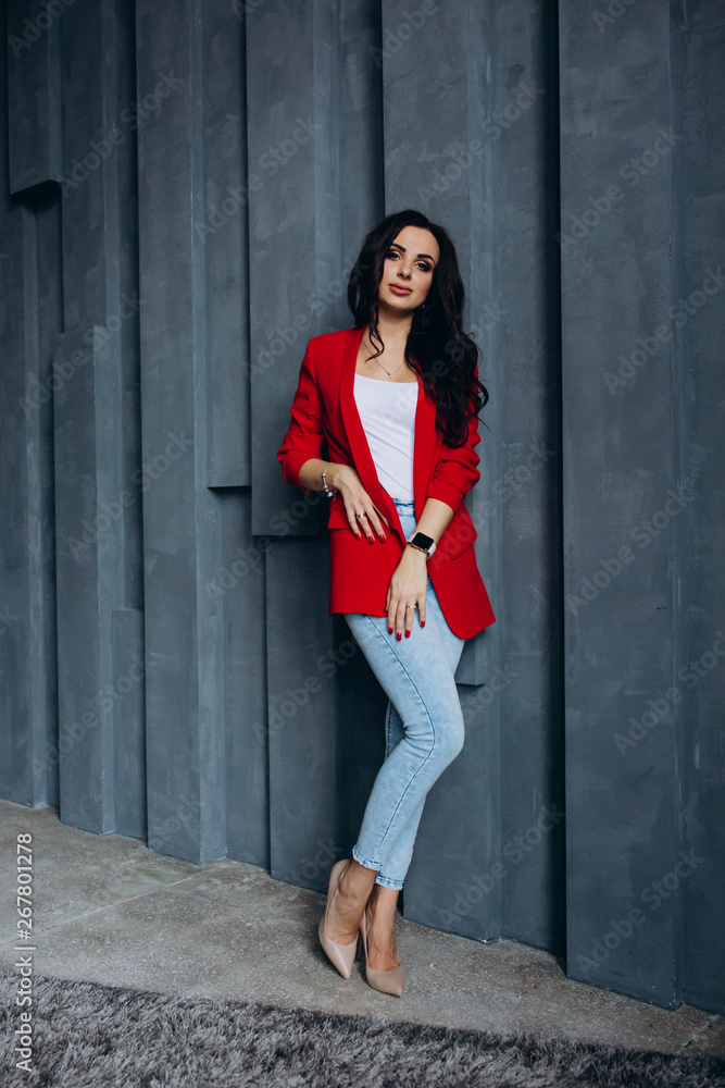 Photo session of a young brunette in jeans and a red jacket. Photo session of a young brunette in jeans and a red jacket.