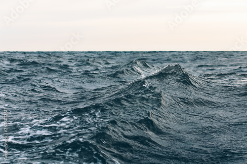 ripples on blue sea water with white foam , natural sea background