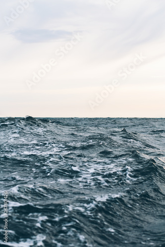 ripples on blue sea water with white foam , natural sea background