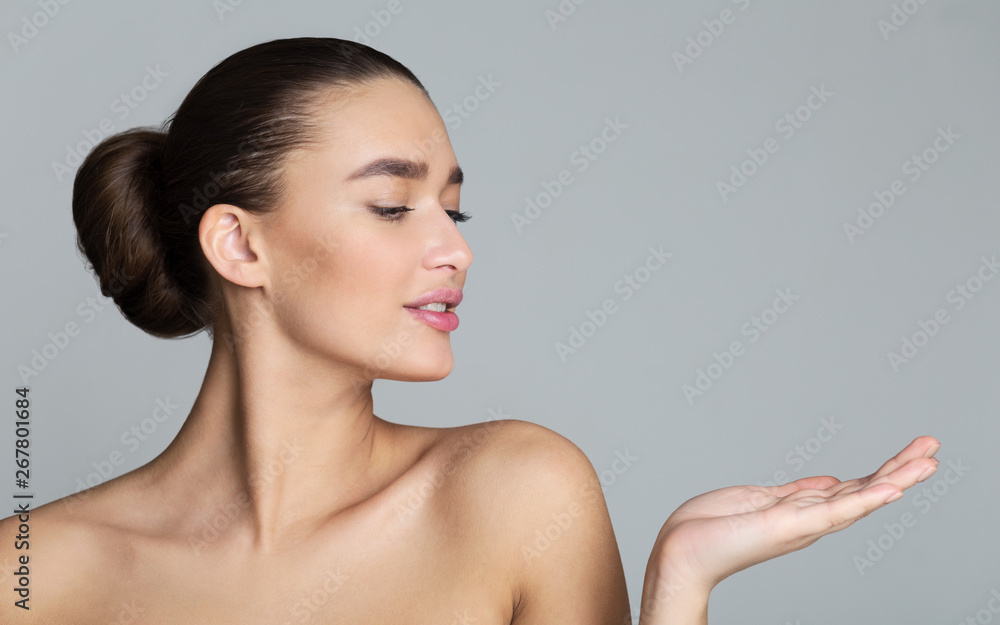 Woman Showing Product And Looking Aside, Copy Space Woman Showing Product And Looking Aside, Copy Space