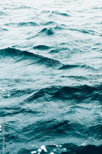 ripples on blue sea water with white foam , natural sea background