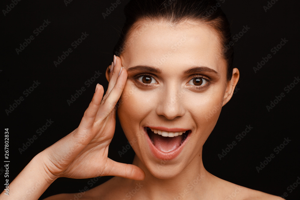 Portrait of a beautiful woman with collected hair and bare shoulders on a black background Portrait of a beautiful woman with collected hair and bare shoulders on a black background