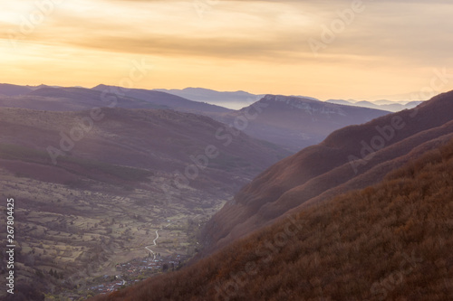 Perfect autumn sunrise above the valley of Dojkinci village and distant horizon mountains