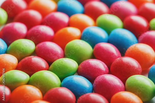 Rainbow colors of multicolored candies close-up, texture and repetition of dragee