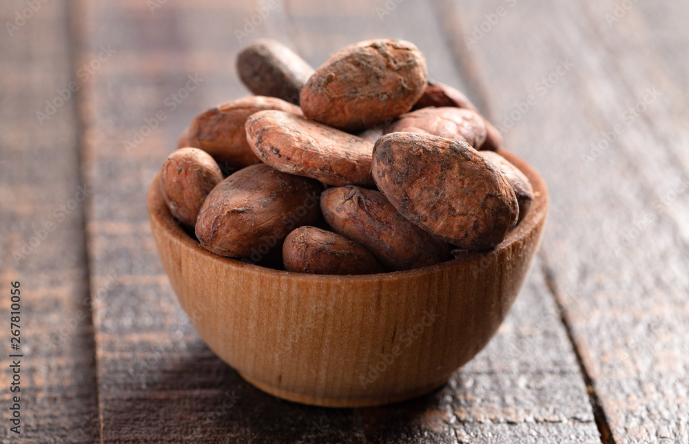 Obraz premium Bowl of Cocoa Beans on a Dark Wooden Table