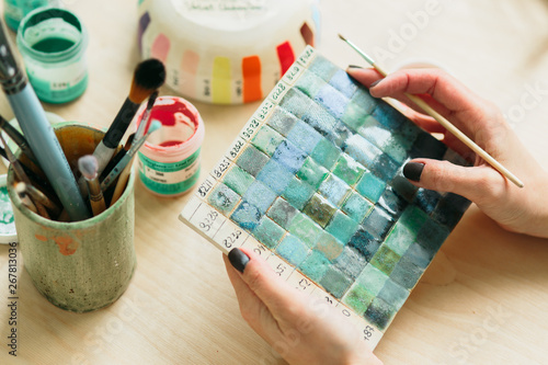 Potter holds the color palette glazes for coating ceramic products