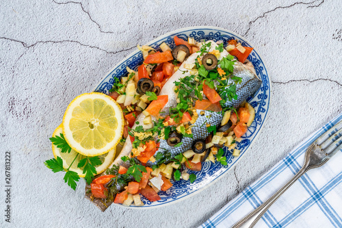 Mediterranean sea bass stuffed with tomatoes, lemons, fennel and olives - top view. Greek cuisine.