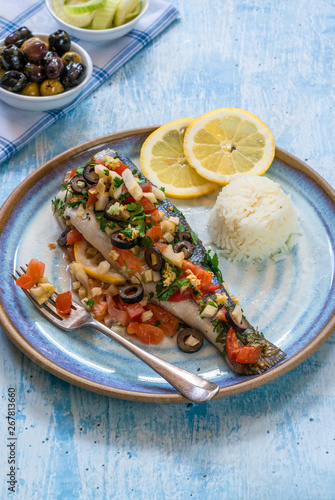 Mediterranean sea bass stuffed with tomatoes, lemons, fennel and olives. Greek cuisine.