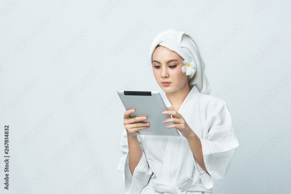 Young Asian women in spa dress with towel on her head and use tablet for social media. Women lifestyle, beauty spa salon and working. - Image Young Asian women in spa dress with towel on her head and use tablet for social media. Women lifestyle, beauty spa salon and working. - Image