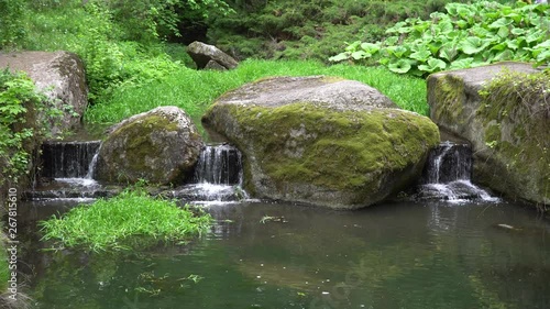 Waterfall in public park, fast streaming water.