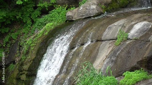 Waterfall in public park, fast streaming water.