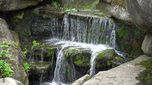 Waterfall in public park, fast streaming water.