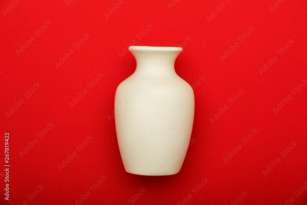 Pottery, vase, white clay jug isolated on red background. Pottery mockup made from white clay on a red background.